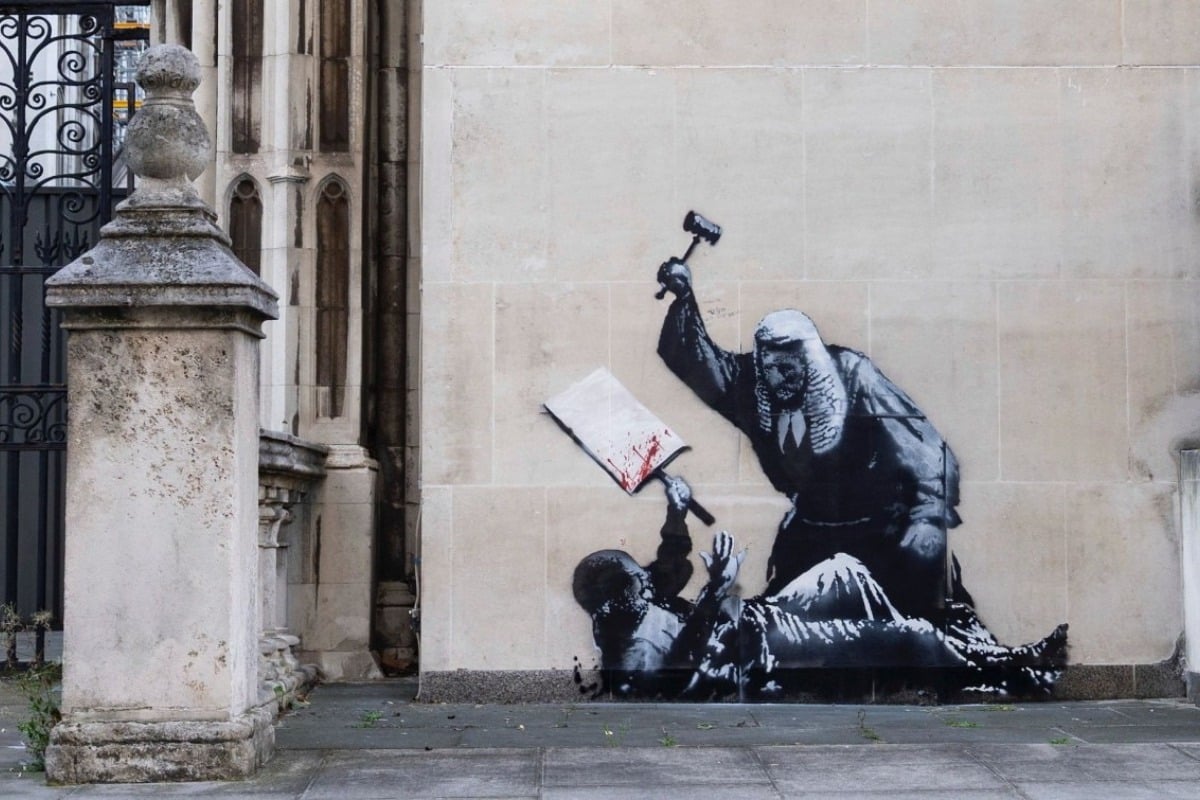 Σάλος με το νέο έργο του Banksy: Δικαστής ξυλοκοπεί διαδηλωτή - Κάλυψαν άρον άρον το γκράφιτι